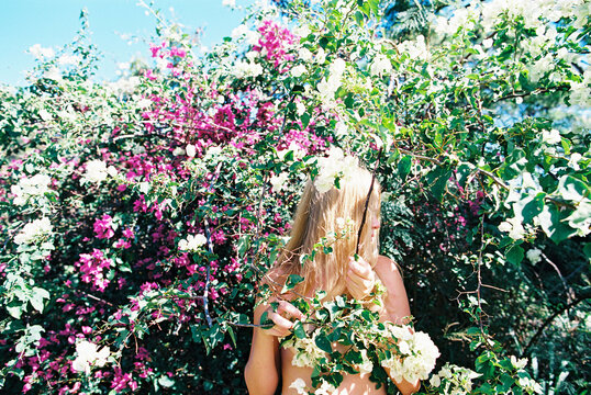 young woman in flowers and nature intertwining with plants