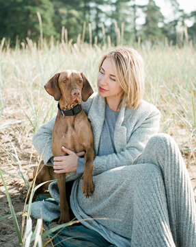 Blonde girl hugs her beloved dog.