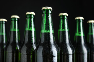Bottles of beer on black background, closeup