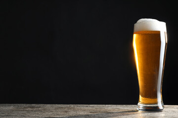Cold tasty beer on grey table against dark background. Space for text