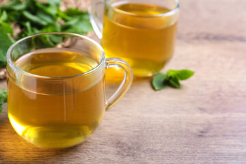 Fresh green tea with mint on wooden table, closeup. Space for text