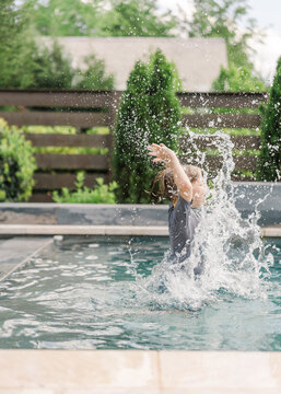 Little boy splashing in a pool