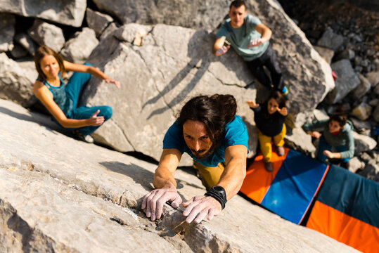 Ehtnic strong climber jumping with two hands on difficult boulder problem