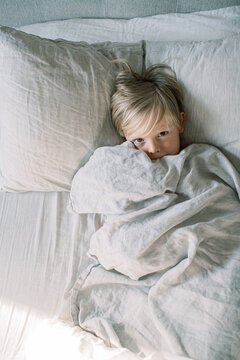 Little boy snuggling in bed