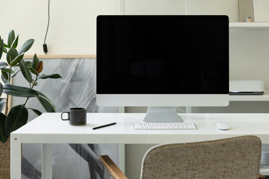 modern desktop computer and coffee mug on white desk in creative space