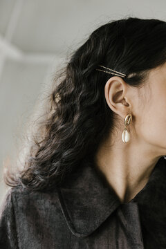 detail of seashell earring on dark haired woman