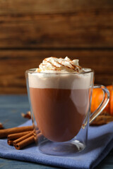 Delicious pumpkin latte on blue wooden table, closeup