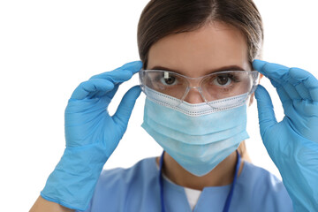 Doctor in medical gloves and protective mask putting on glasses against white background, closeup