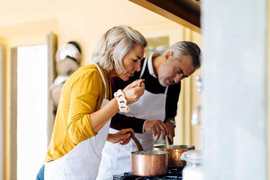 Mature woman cooking lunch with husband