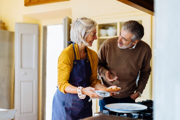 Happy couple talking during pie preparation