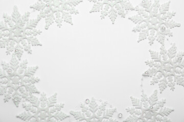 Fototapeta premium Beautiful decorative snowflakes on white background, flat lay. Space for text
