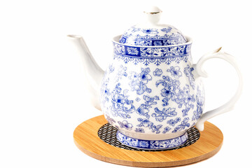 Faience teapot for tea on a stand on an isolated white background.