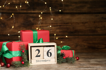 Block calendar with Boxing Day date near gifts on wooden table. Space for text - Powered by Adobe