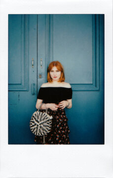 Beautiful Redhead Woman with Bag on Blue Background