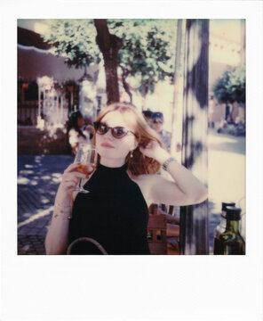 Stylish Young Redhead Woman Enjoying the Orange Drink in the Restaurant Garden