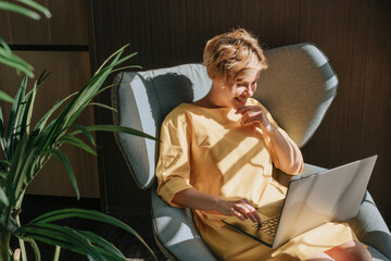 A young woman in the process of working at the computer at home.
