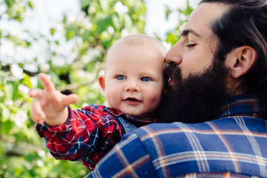Father kissing baby in garden
