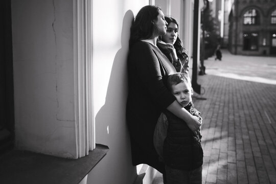 Black and white portrait of a mother with teenager daughter and little son.