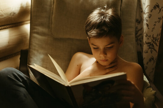 A young boy reads a book.