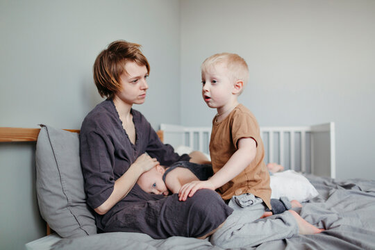 Sick little children with their mother in the bedroom.