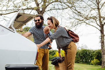 Happy family unloading car trunk
