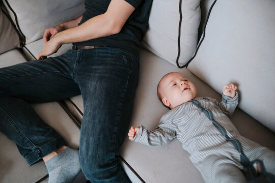 A newborn next to his father at home.
