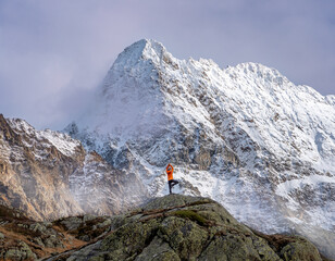 Women in yoga tree pose in front of snow covered mountain