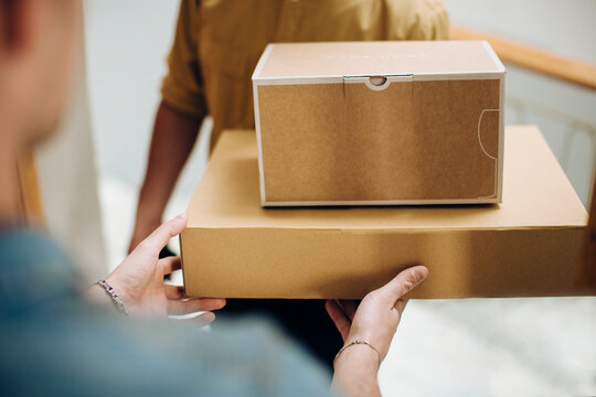 Anonymous customer taking blank packages from courier