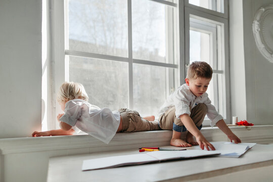 Little boys drawing in the white room.