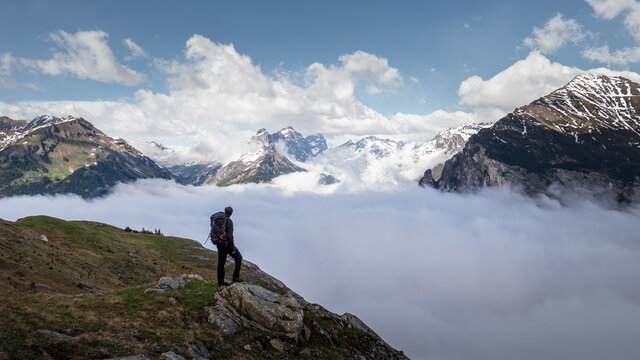 Man standing alone above the clouds in the Swiss Alps