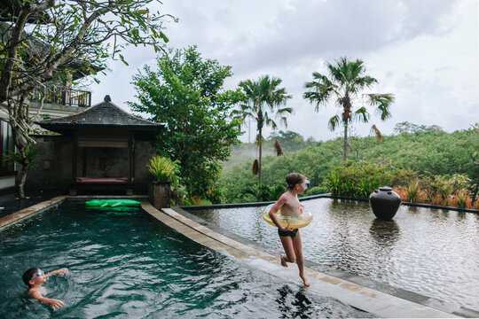 Young boys brothers in a tropical pool.
