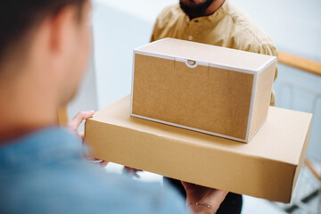 Crop customer taking boxes from courier