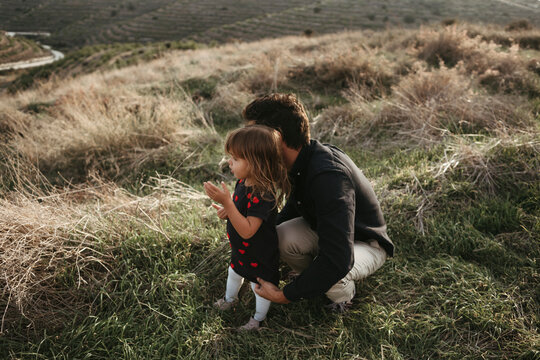 A father walking with a small daughter outdoor.