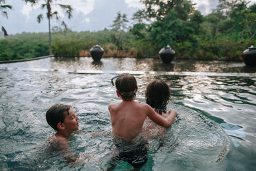 Young boys brothers in a tropical pool.