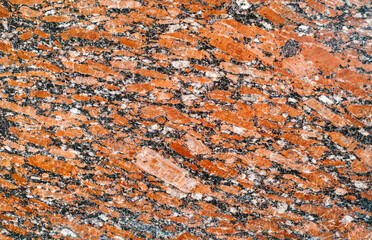 Background with a texture of natural red granite. Polished stone surface, copy space.
