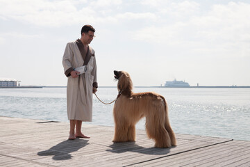 Portrait of man walking the Afghan dogs