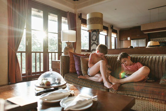 Young brothers use gadgets at home.