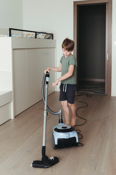 A young boy is cleaning the room.