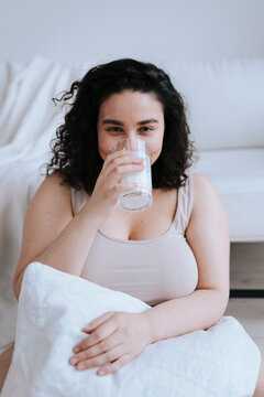 A young plus size woman with glass of milk.