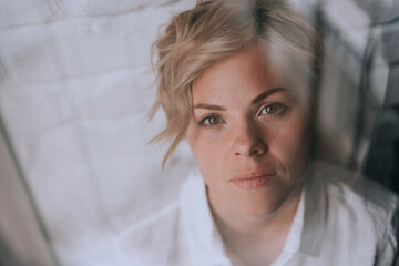 Portrait of a young woman at the window.