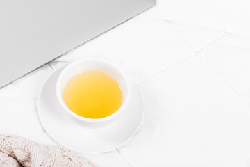 Tea, blanket, and laptop on the bed. White Background, copy space.