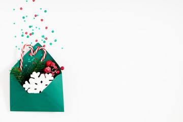 Christmas creative minimal composition. Xmas red and green decorations on white background. Christmas, New Year, winter concept. Flat lay, top view, copy space
