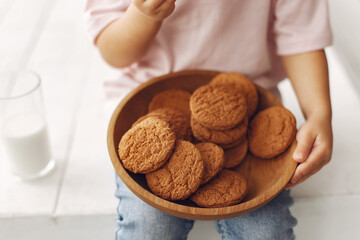 Child in a studio. Little girl with a cookies. Girl in a pink t-shirt