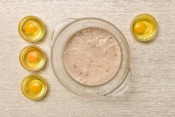 Cooked eggs in cups. And a bowl of yeast diluted in milk.