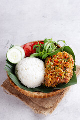 Ayam Geprek is Popular Street Food in Indonesia. Made from Crispy Chicken Smashed in Sambal Bawang (Chilli Garlic Sauce) . Served with Rice and Vegetable.