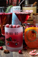 A variety of Christmas cocktails on a wooden table, ready for drinking.