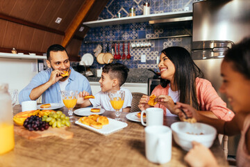 Latin family eating healthy breakfast in the kitchen