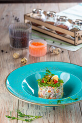 plate with olivier salad on wooden background, close view 
