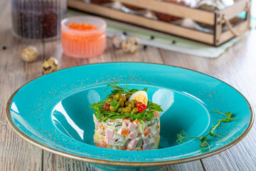 plate with olivier salad on wooden background, close view 
