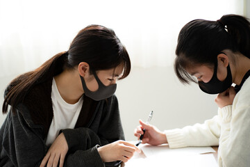 勉強を教えあうマスクをつけた日本人女の子